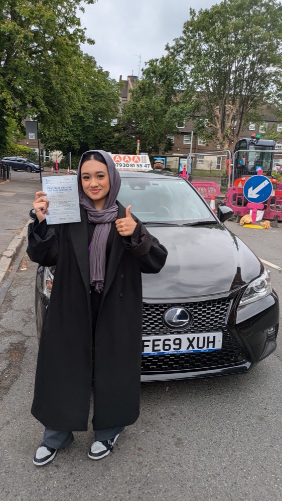 Auto Pass student giving a thumbs up with her pass certificate by the Lexus tuition car